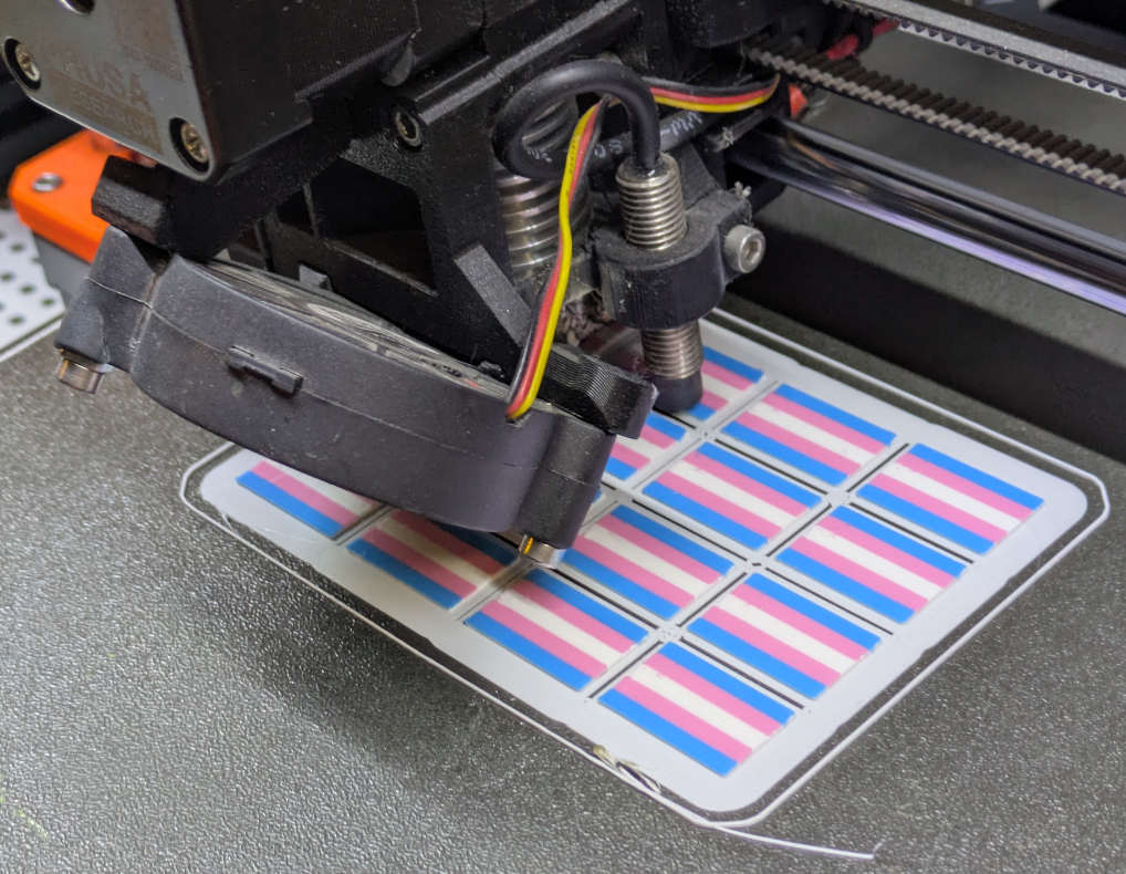 16 trans flags being 3d printed