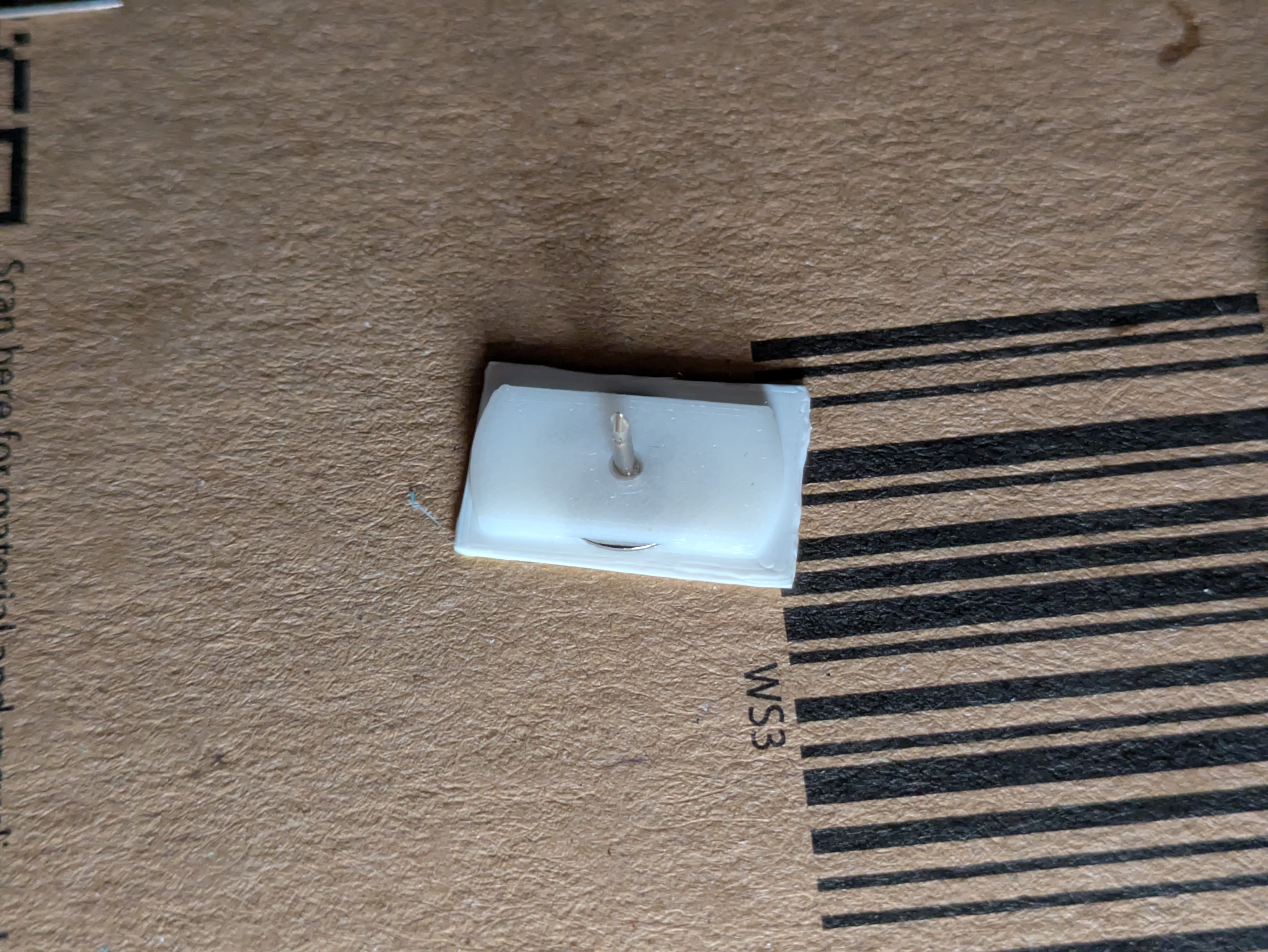 the back of a flag with a pin secured by a glued piece of plastic